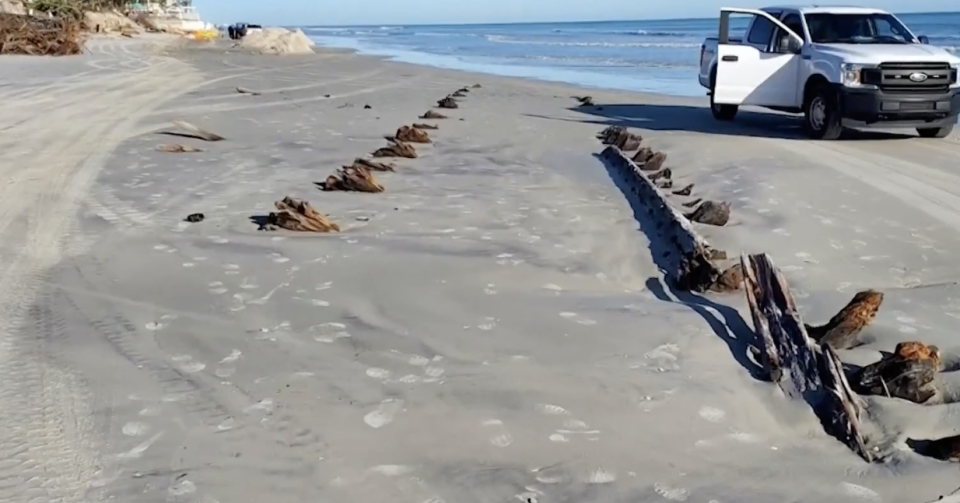 Beachgoers in Florida discovered a mysterious object buried underneath the sand, perplexing locals and officials. It appears to be a wooden structure. / Credit: Volusia Beach Safety