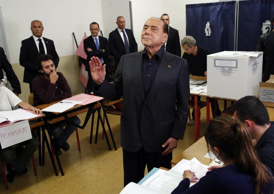 FILE - Former Italian Premier Silvio Berlusconi waves to photographers as he arrives to vote for the European Parliament elections at a polling station in Milan, Italy, on May 26, 2019. Berlusconi, the boastful billionaire media mogul who was Italy's longest-serving premier despite scandals over his sex-fueled parties and allegations of corruption, died, according to Italian media. He was 86. (AP Photo/Antonio Calanni, File)
