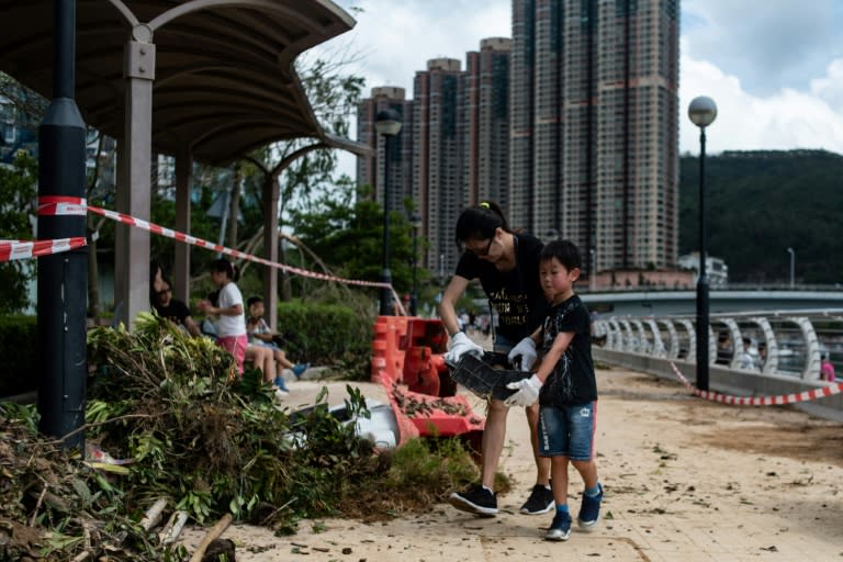 Volunteers pick up debris on the promenade in Tseung Kwan O district in the aftermath of Typhoon Mangkhut