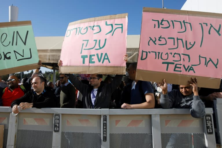 Israeli employees of Teva, the world's biggest manufacturer of generic drugs, hold placards during a protest in the centre of Jerusalem on December 17, 2017, against plans by the pharmaceutical giant to shed employees