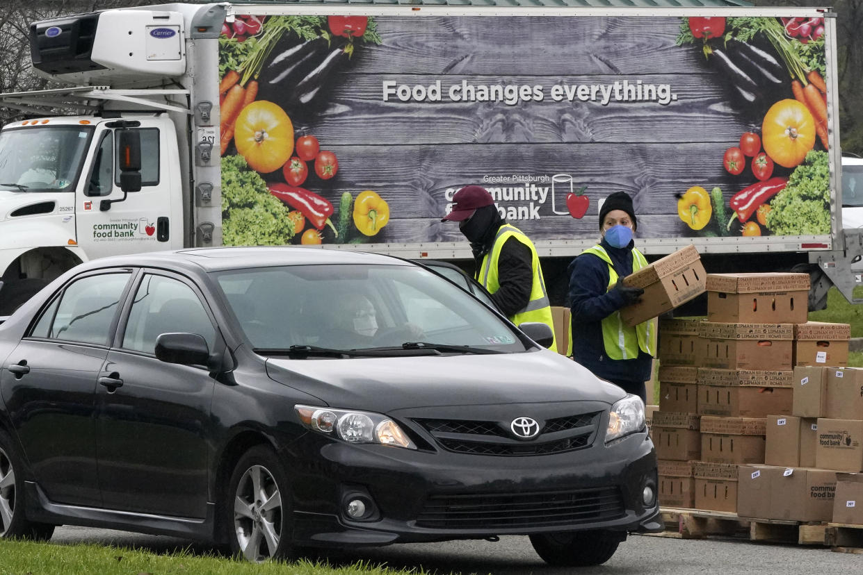 Volunteers load boxes of food into a car during a Greater Pittsburgh Community Food bank drive-up food distribution in Duquesne, Pa., Monday, Nov. 23, 2020. (AP Photo/Gene J. Puskar)