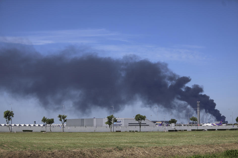 Smoke billows high into the air behind the Suvarnabhumi Airport in the Samut Prakan province, Thailand, Monday, July 5, 2021. A massive explosion at a factory on the outskirts of Bangkok early Monday shook an airport terminal serving Thailand's capital and prompted the evacuation of residents from the area. (AP Photo/Nava Natthong)