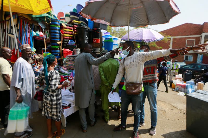 Health workers direct people to the venue of a COVID-19 mass vaccination exercise in Abuja