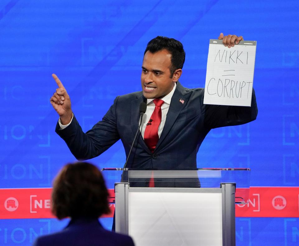 Vivek Ramaswamy holds up a sign during the fourth Republican Presidential Primary Debate.