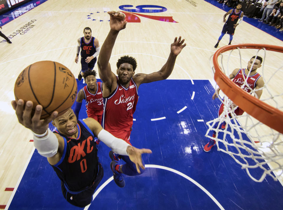 Russell Westbrook braces for Joel Embiid’s attempt to swat his shot from behind. (AP Photo/Chris Szagola)