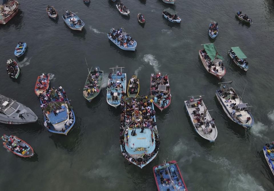 Los pescadores siguen una estatua de San Pedro que es transportada en un bote, en el centro, como parte de una procesión en el Océano Pacífico en honor del santo patrón católico de los pescadores en su fiesta en Pucusana, Perú, el miércoles 29 de junio de 2022. ( Foto AP/Martín Mejia)
