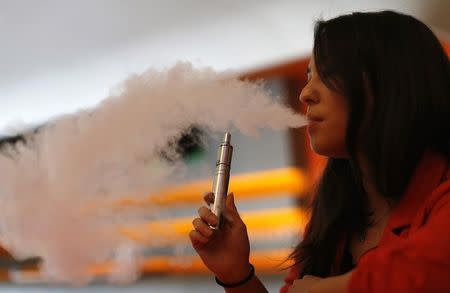 Enthusiast Brandy Tseu uses an electronic cigarette at The Vapor Spot vapor bar in Los Angeles, California March 4, 2014. The Los Angeles City Council voted unanimously on Tuesday to ban the use of electronic cigarettes, popularly known as "vaping," from restaurants, bars, nightclubs and other public spaces within the nation's second-largest city. REUTERS/Mario Anzuoni