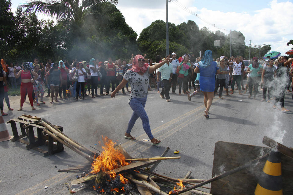 Relatives protest for more information, outside the Anisio Jobim Prison Complex where a deadly riot erupted among inmates in the northern state of Amazonas, Brazil, Sunday, May 26, 2019. A statement from the state prison secretary says prisoners began fighting among themselves around noon Sunday, and security reinforcements were rushed to complex. (AP Photo/Edmar Barros)