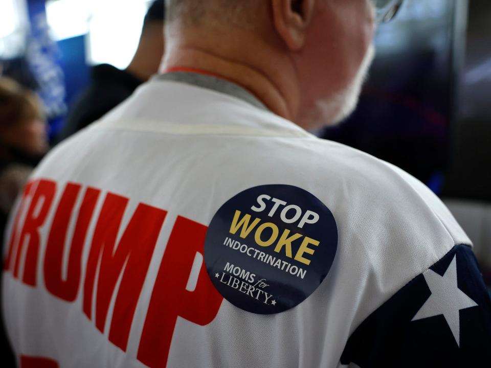 A man wears a “Stop Woke Indoctrination” sticker at CPAC 2023.