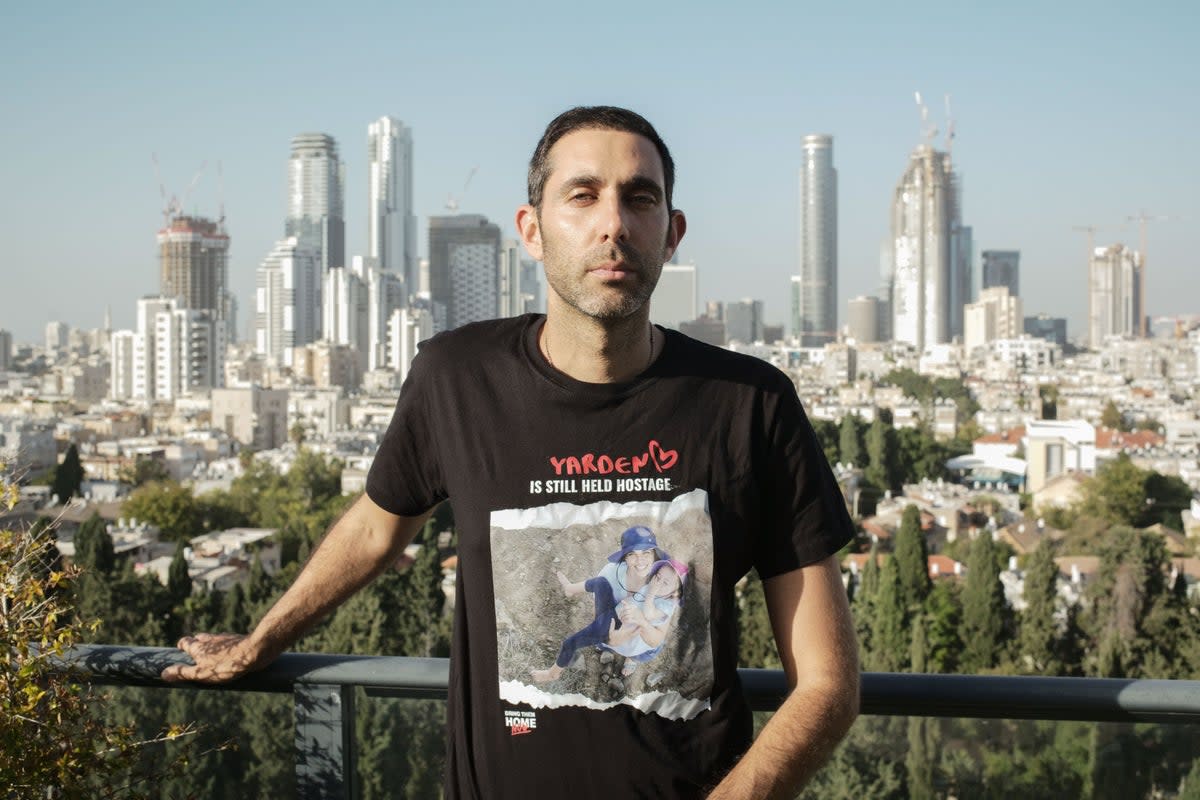 Gili Roman, brother of Yarden Roman-Gat, stands on the balcony of his family’s apartment in Tel Aviv (Tom Bennett)