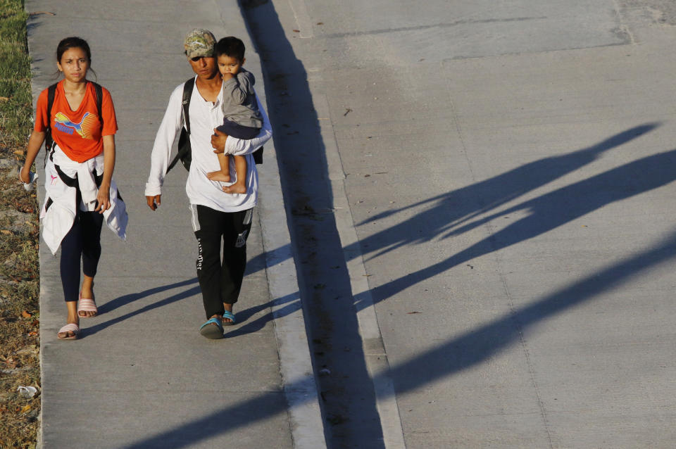 Tres migrantes parten a pie el martes 30 de marzo de 2021 de San Pedro Sula, Honduras, con rumbo a Estados Unidos. La Organización Panamericana de la Salud pidió el miércoles a los migrantes de Latinoamérica que durante la pandemia de coronavirus no viajen porque ponen en riesgo su vida, la de sus familias y la de las comunidades por las que se trasladan. (AP Foto/Delmer Martínez)