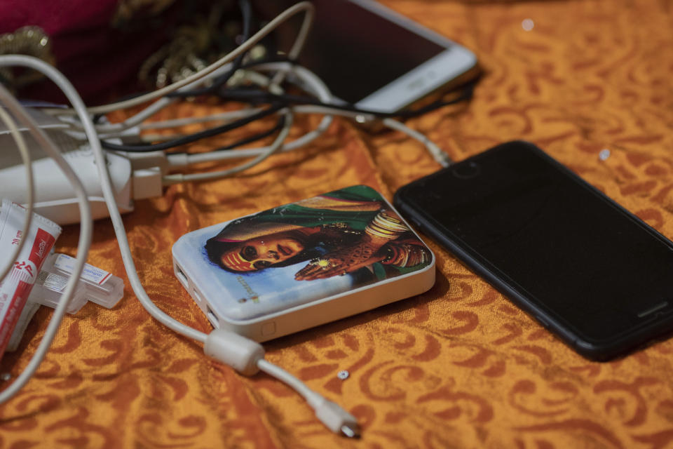 In this Jan. 13, 2019, photo, a power bank is seen with a picture of Laxmi Narayan Tripathi, an Indian transgender activist and leader of the "Kinnar akhara" monastic order, during the Kumbh Mela festival in Prayagraj, India, Sunday. Tripathi is trying to break into the male-dominated world of Hinduism’s high priests gathered this month for the weeks-long Kumbh Mela festival with her newly formed Kinnar Akhara which has set up camp at the massive temporary city in Prayagraj. Unlike other akharas, which are only open to Hindu men, Kinnar, founded in 2015, is open to all genders and religions. (AP Photo/Bernat Armangue)
