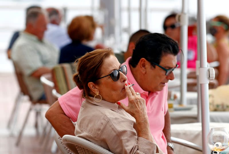 A woman smokes at the terrace of a restaurant, during the spread of the coronavirus disease (COVID-19) pandemic, in Las Palmas