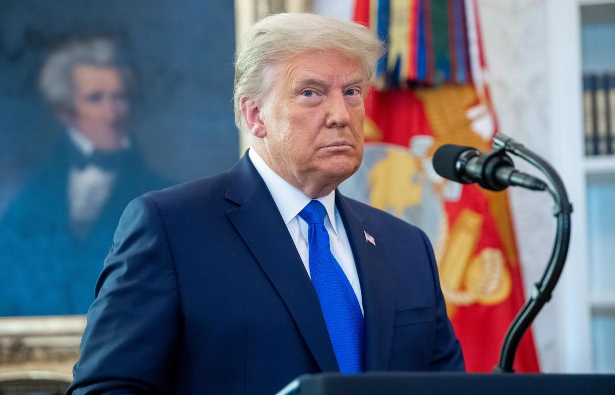 In this photo taken on December 7, 2020 US President Donald Trump looks on during a ceremony presenting the Presidential Medal of Freedom to wrestler Dan Gable in the Oval Office of the White House in Washington, DC.