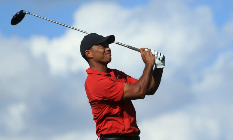 Tiger Woods in his follow through after hitting a golf ball.