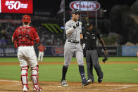 New York Yankees' Aaron Judge, center, gestures as he scores after hitting a three-run home run while Los Angeles Angels catcher Max Stassi, left, watches along with home plate umpire Alan Porter during the fourth inning of a baseball game Tuesday, Aug. 30, 2022, in Anaheim, Calif. (AP Photo/Mark J. Terrill)