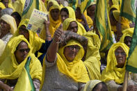 Farmer women sit in the sun as Indian farmers who have been protesting to demand guaranteed crop prices gather at Ramlila ground in New Delhi, India, Thursday, March 14, 2024. (AP Photo)