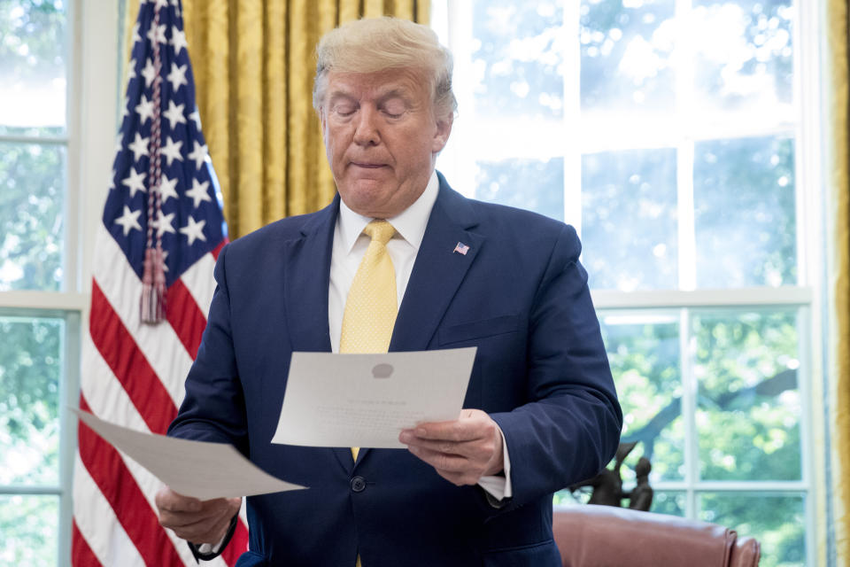 President Donald Trump holds a letter presented to him by Chinese Vice Premier Liu He, left, in the Oval Office of the White House in Washington, Friday, Oct. 11, 2019. (AP Photo/Andrew Harnik)