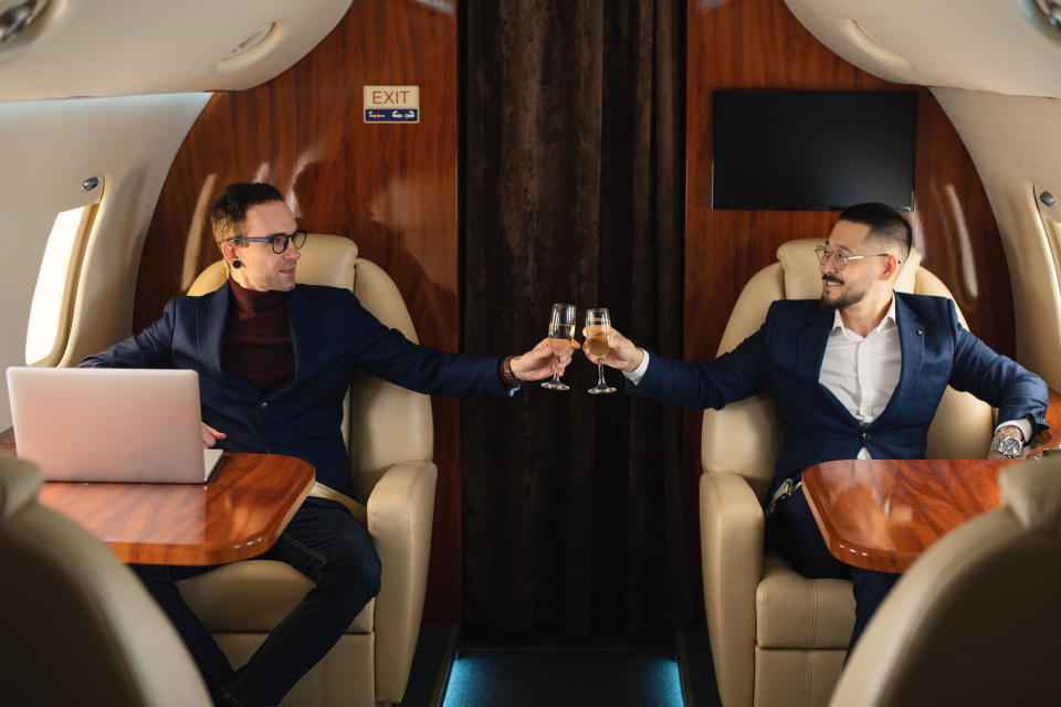 Men clinking glasses on a private plane