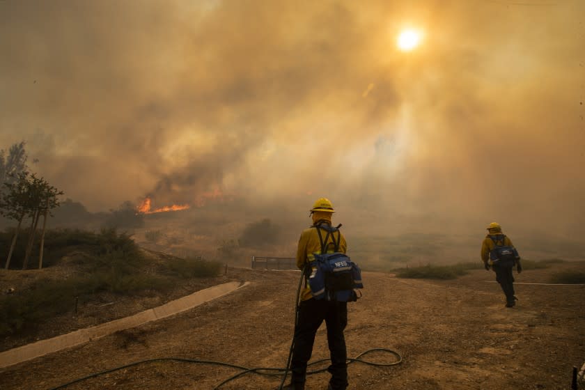 As the Silverado fire approaches the Orchard Hills neighborhood of Irvine Monday, firefighters stand ready to defend homes.