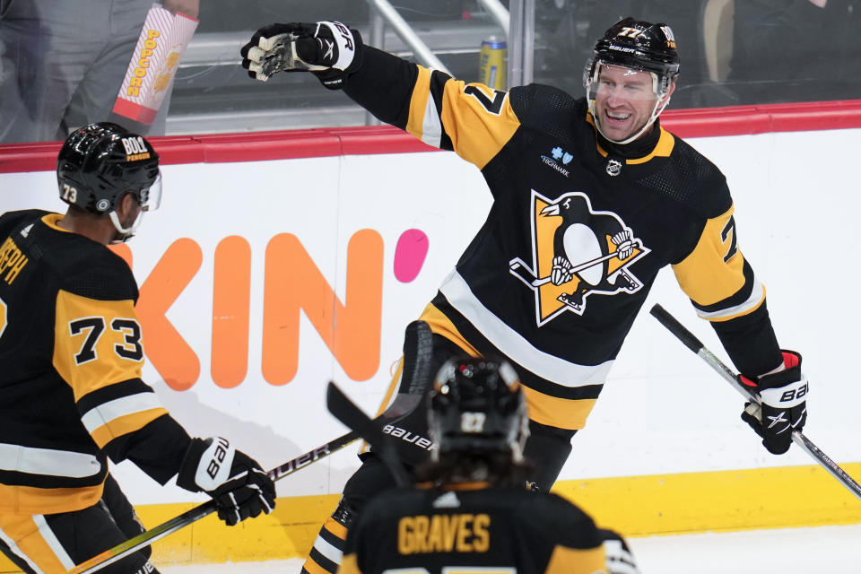 Pittsburgh Penguins' Jeff Carter (77) celebrates his goal with Pierre-Olivier Joseph (73) and Ryan Graves (27) during the first period of an NHL hockey game against the Arizona Coyotes in Pittsburgh, Tuesday, Dec. 12, 2023. (AP Photo/Gene J. Puskar)