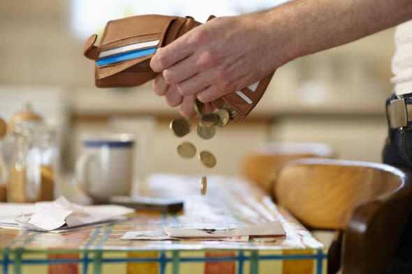 Man emptying coins from wallet.