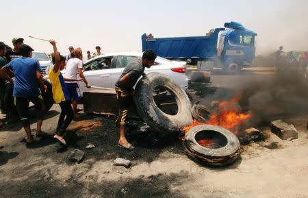 Iraqi protesters burn tires and block the road at the entrance to the city of Basra, Iraq July 12, 2018. REUTERS/Essam al-Sudani