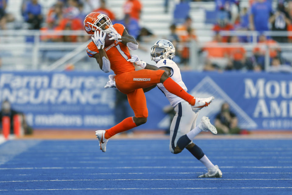 Boise State wide receiver Octavius Evans (1) catches the ball in front of Nevada defensive back AJ King (4) in the second half of an NCAA college football game Saturday, Oct. 2, 2021, in Boise, Idaho. (AP Photo/Steve Conner)