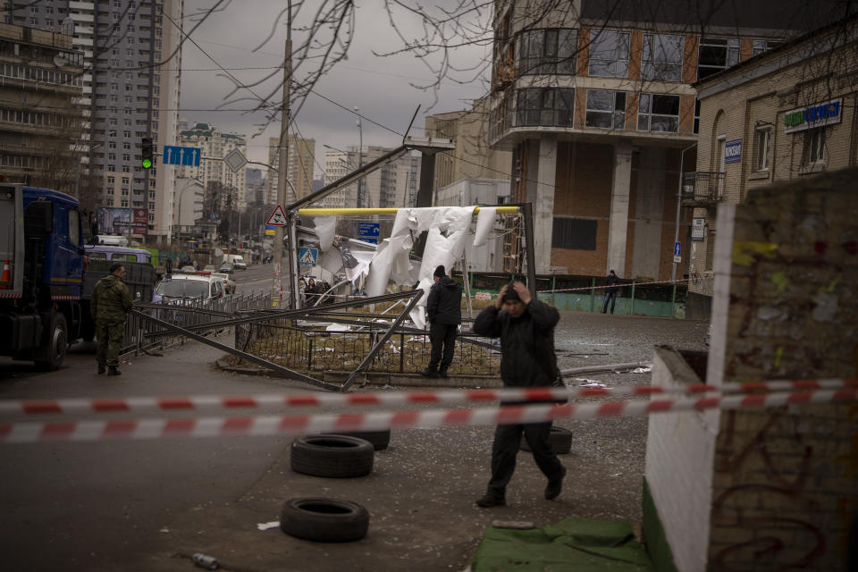 FILE - Police officers inspect area after an apparent Russian strike in Kyiv Ukraine, Thursday, Feb. 24, 2022. On the battlefields of Ukraine, the fog of war plagues soldiers. A related issue afflicts those who are far from the fighting but avid to learn developments in the vast war. Disinformation, misinformation and absent information all cloud civilians’ understanding. Officials from each side denounce devious plots being prepared by the enemy, which never materialize. They claim victories that can’t be confirmed and stay quiet about defeats.AP Photo/Emilio Morenatti, File)