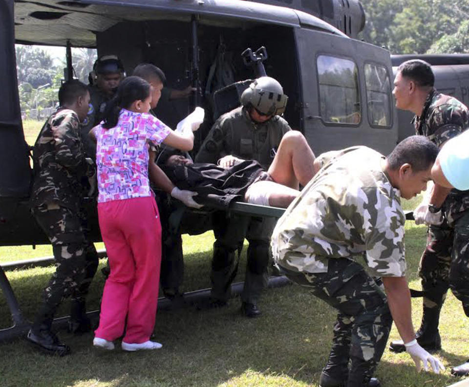 Philippine troops rush a victim injured in a bombing to a military hospital after being airlifted from the site of an improvised explosive devise explosion Saturday, Feb. 1, 2014 at Datu Saudi Ampatuan township, Maguindanao province in southern Philippines. A homemade bomb that was likely set off by Muslim rebels in the southern Philippines on Saturday wounded 12 people, including six soldiers and two television journalists, the military said. The blast happened near an area where government troops have been battling Muslim insurgents who broke away from a larger rebel group after it signed a peace deal with the government. (AP Photo)