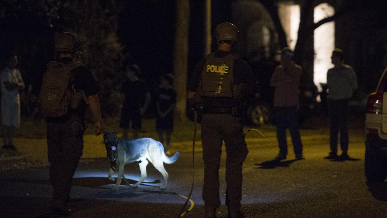 Polizisten mit Bombenspürhund am Ort der Explosion in Austin. Foto: ick Wagner/Austin American-St/AP