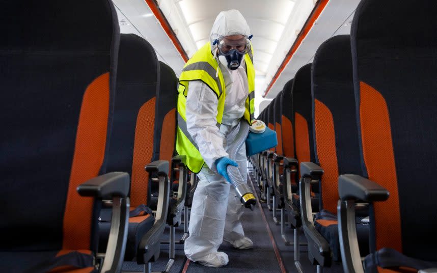 Deep clean: A member of easyJet staff wears protective clothing to decontaminate an aircraft - part of measures to prevent a second wave of coronavirus - MATT ALEXANDER/PA