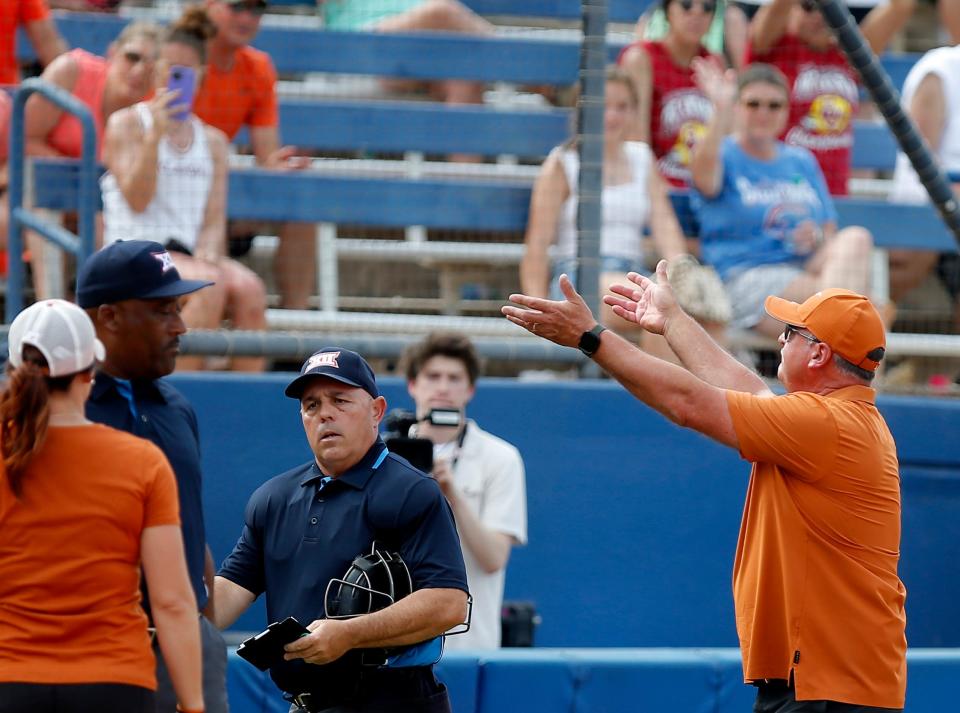 Texas softball coach Mike White motions to fans after being ejected during the Big 12 semifinals against OSU on May 13. White was tossed from the game after arguing an umpire's call and flashing an obscene hand gesture.