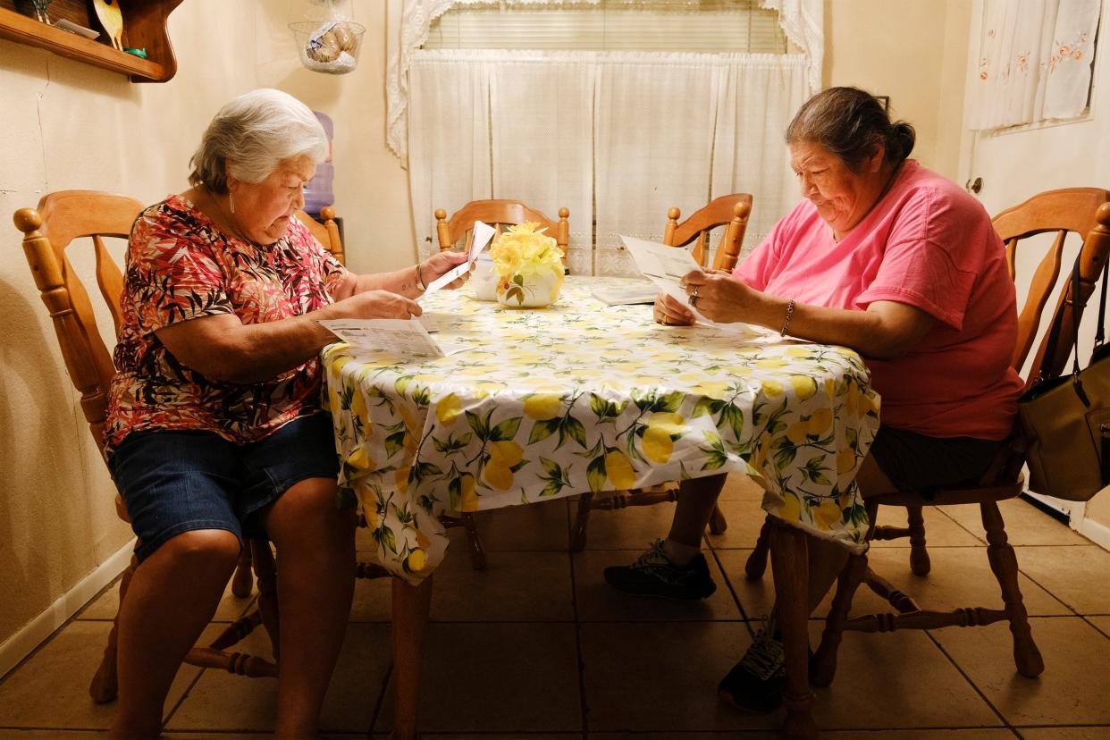 Olivia R. Hernandez, left, 82, and daughter Debbie Hernandez, 61, review their utility bills at the dining table. They have had to rely on relatives for transportation after their vehicle stopped working last year.