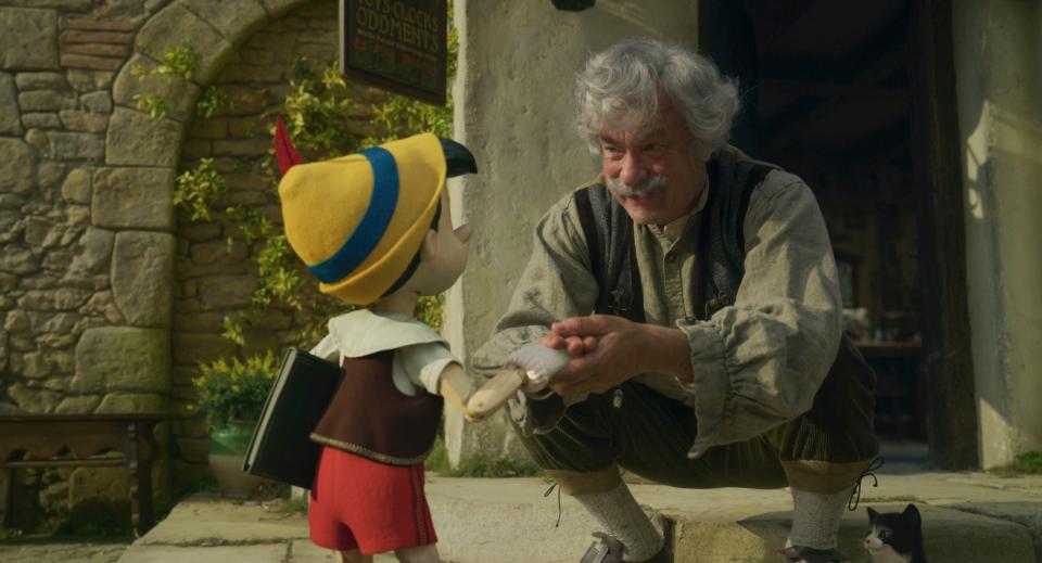 Geppetto (Tom Hanks, right) cares for his beloved wooden creation (voiced by Benjamin Evan Ainsworth) in Disney's live-action "Pinocchio."