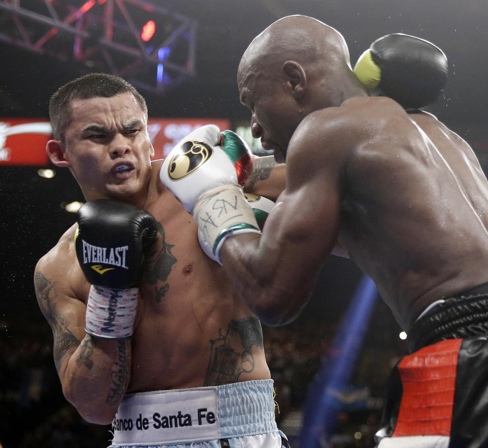 Marcos Maidana, left, from Argentina, trades blows with Floyd Mayweather Jr. in their WBC-WBA welterweight title boxing fight Saturday, May 3, 2014, in Las Vegas. (AP Photo/Isaac Brekken)