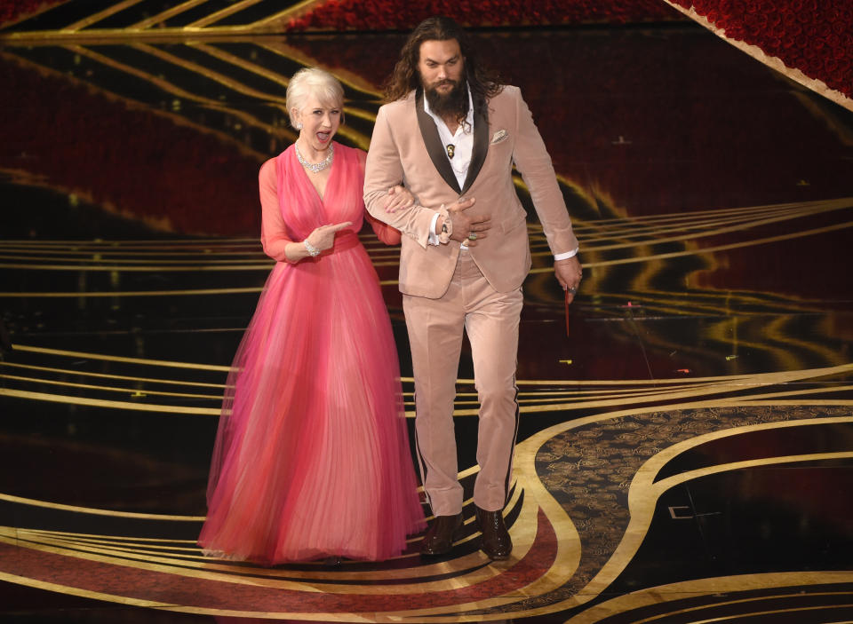 Helen Mirren, left, and Jason Momoa present the award for best documentary feature at the Oscars on Sunday, Feb. 24, 2019, at the Dolby Theatre in Los Angeles. (Photo by Chris Pizzello/Invision/AP)