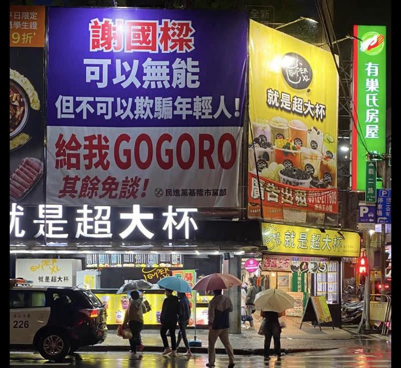 民進黨基隆市黨部選前懸掛看板，質疑謝國樑開出送年輕人Gogoro政見。（圖／翻攝自張之豪臉書）