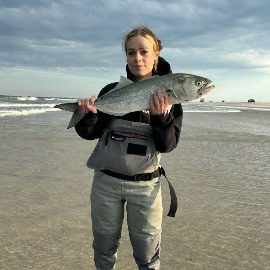 Liz Ribas holds up a bluefish from the surf action this week on the Ocean County beaches.