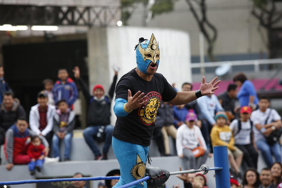 Mexican wrestler Relampago Veloz encourages the crowd during a "lucha libre" fight in Mexico City, Saturday, Dec. 21, 2019. Mexican wrestling, otherwise known as the “lucha libre,” is a highly traditional form of light entertainment. (AP Photo/Ginnette Riquelme)