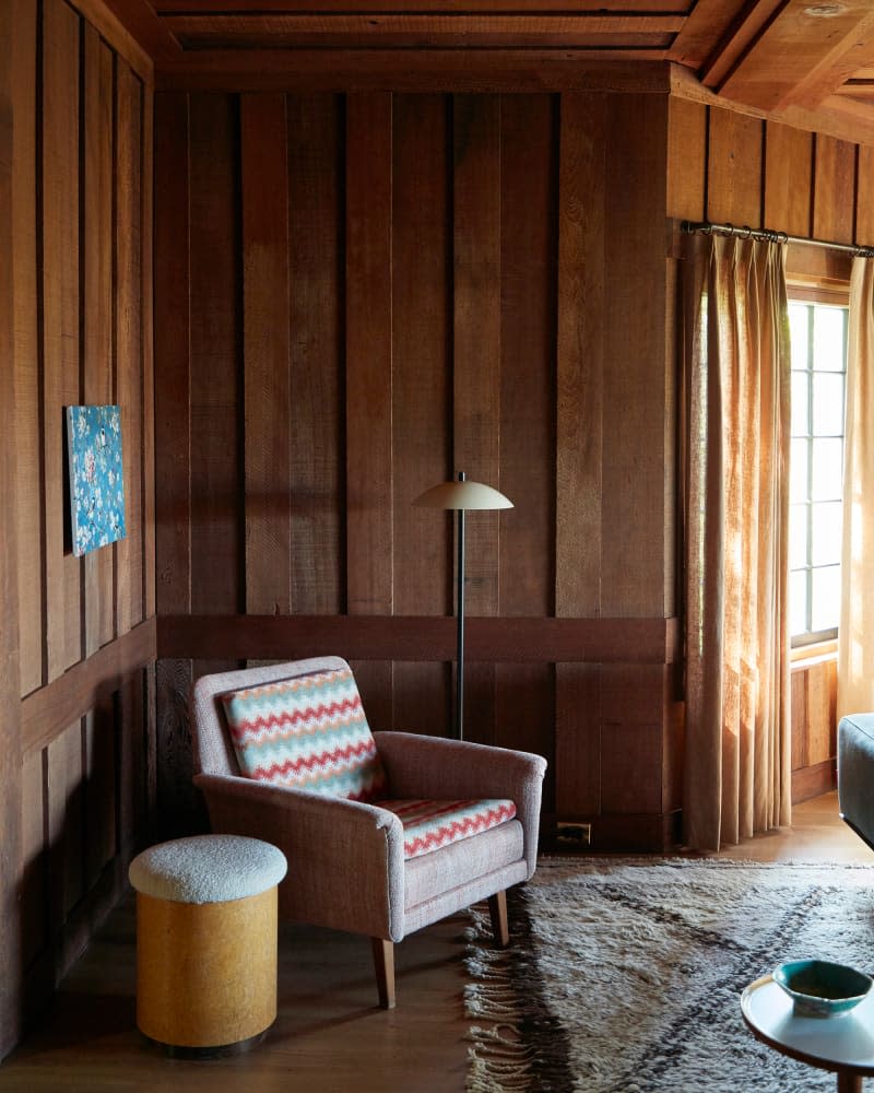 Armchair in corner of newly remodeled wood paneled room.