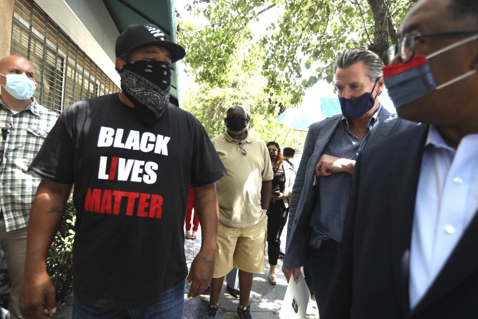 Abu Hussain, left, shares his concerns with California Gov. Gavin Newsom and Los Angeles Supervisor Mark Ridley-Thomas while the governor was visiting businesses in Leimert Park in Los Angeles on Wednesday, June 3, 2020. (Genaro Molina/Los Angeles Times via AP, Pool)