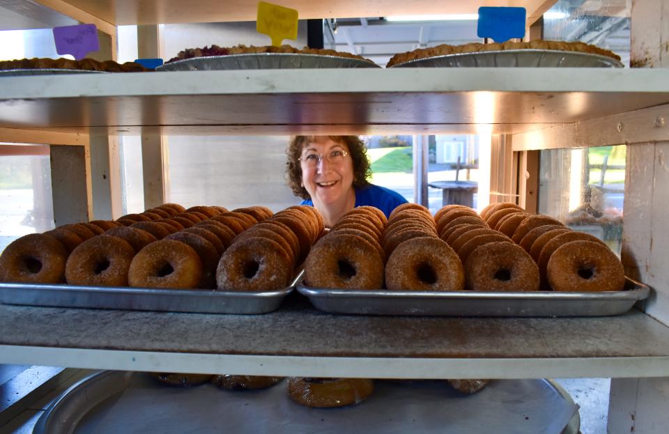 Jeannine Ridgeway, granddaughter of Tantillo's Farm Market founder Leonard Tantillo, smiles from behind a display of freshly made apple cider donuts Saturday, Oct. 28.
