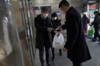 Security personnel checks temperature of a customer entering Alibaba's Hema Fresh chain store, following the coronavirus outbreak, in Beijing