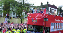 Arsenal's players and their families arrive on the open-top bus at Islington Town Hall to celebrate their title triumph (MARTYN HAYHOW/AFP/Getty Images)