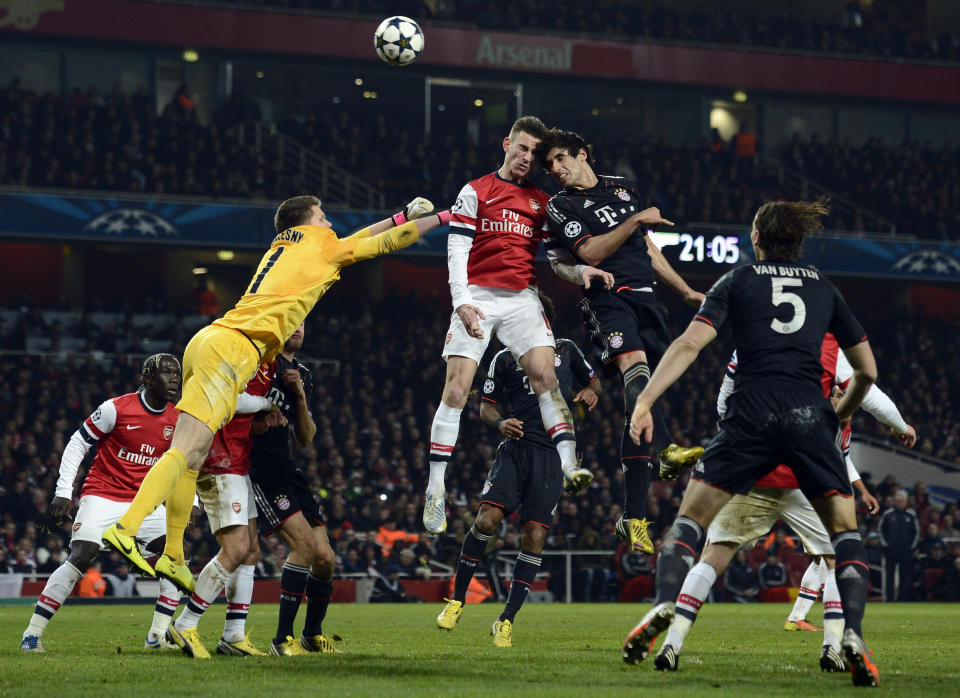 Arsenal's goalkeeper Wojciech Szczesny (L) and Laurent Koscielny (C) challenge Bayern Munich's Javi Martinez during their Champions League soccer match at the Emirates Stadium in London February 19, 2013. REUTERS/Dylan Martinez (BRITAIN - Tags: SPORT SOCCER TPX IMAGES OF THE DAY) - RTR3E06O