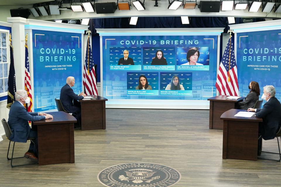 President Biden and Vice President Kamala Harris, flanked by two other masked officials at the White House, address five members of the COVID-19 response team at a teleconference. 