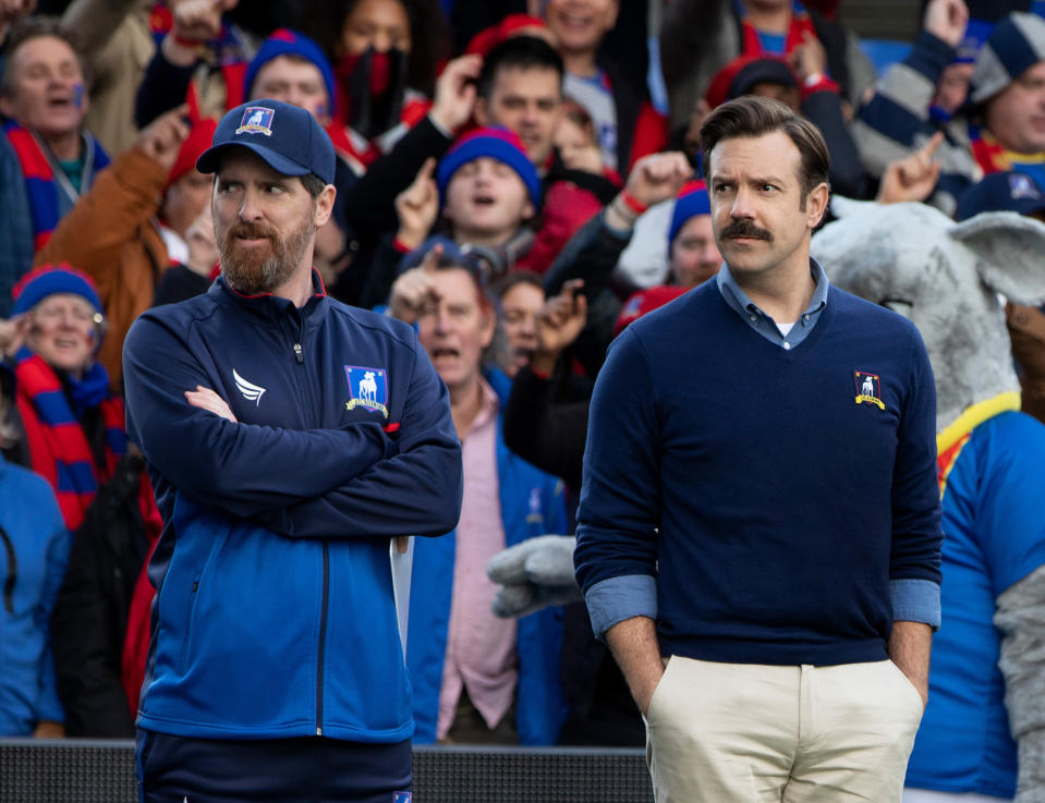 This image released by Apple TV Plus shows Brendan Hunt, left, and Jason Sudeikis in “Ted Lasso,” premiering globally on Friday, August 14. (Apple TV Plus via AP)