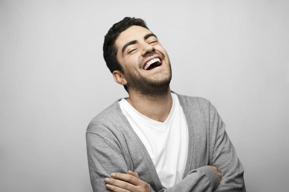 Man in cardigan laughing