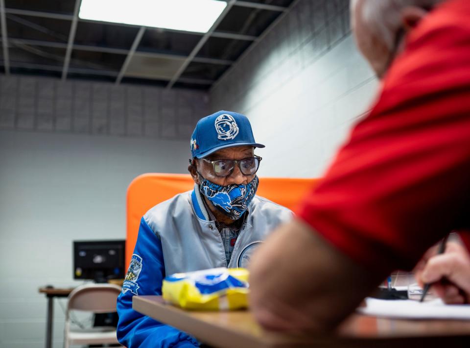 Detroit resident Cornelius Chatman talks with volunteer tax preparer Rick Pacynski while getting his taxes done for free at Ford Resource and Engagement Center-East in Detroit on Thursday, January 26, 2023.